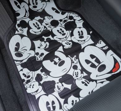 A car floor mat features multiple illustrations of Mickey Mouse, resting inside a vehicle.